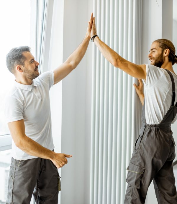 Workmen installing radiator at home